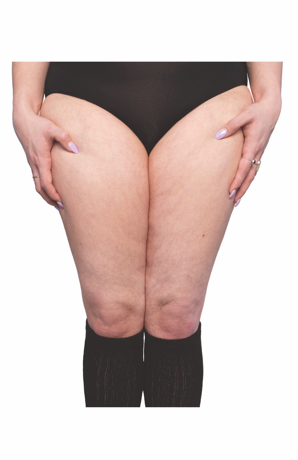 The thighs of a woman wearing black underwear and black socks